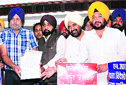 A representative of the NRI families hands over memorandum to Jasvir Singh Gill, president of the Punjab NRI Sabha, against the implementation of 12.36 per cent tax on the remittance sent by NRIs to Punjab