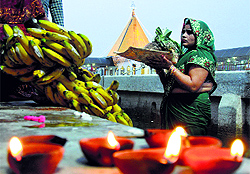 A devotee prays to the Sun God as part of the Chhath puja at the Devi Talab temple pond in Jalandhar on Wednesday