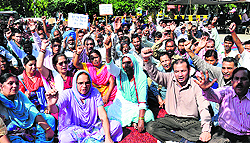 Members of Private College Non-Teaching Employees Union raise anti-government slogans outside the District Administration Complex at Jalandhar on Wednesday