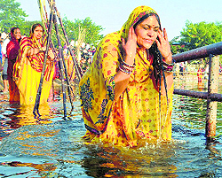 Devotees take a holy dip and offer prayers during Chhath in Ranchi on Wednesday