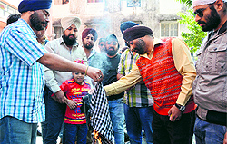 Family members of the victims burn a turban of the accused