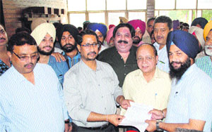 Local Bodies Minister Anil Joshi hands over the NOC for regularisation of property to an applicant at the Municipal Town Planing office in Amritsar on Thursday
