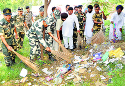 BSF officials and jawans clear garbage as part of the Swachh Bharat Abhiyan at Khalra in Tarn Taran on Thursday