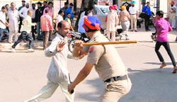 A policeman resorts to a lathicharge in Phase VI, Mohali, on Friday. A tribune photograph