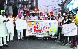 AAP workers hold a candle march demanding justice for the 1984 anti-Sikh riot victims in Bathinda on Saturday.