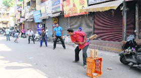 Shopkeepers play cricket in a closed market during the bandh.