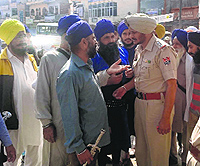 Police officials try to stop protesters marching with swords in Gurdaspur