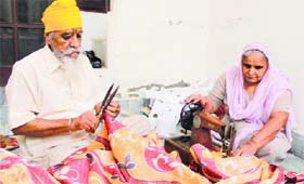 Uttam Singh, once a landlord at Hondh-Chillar, helps his wife Jaswant Kaur (right) in tailoring assignments to keep the kitchen going.