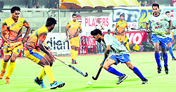 Players of Rail Coach Factory (in blue) and Indian Overseas Bank in action during their match in the Surjit Hockey Tournament in Jalandhar on Saturday