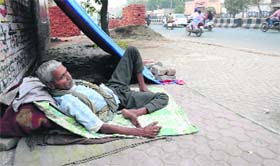 A homeless person takes shelter on a footpath in Bathinda.