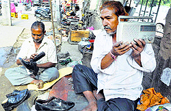 Cobblers listen to Mann ki Baat addressed by Prime Minister Narendra Modi on a radio at Beawar, Rajasthan, on Sunday