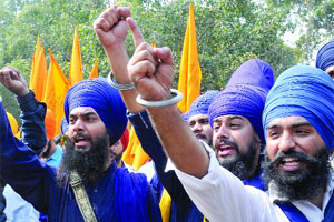 Activists of the Dal Khalsa raise slogans during a protest at Jantar Mantar, demanding  justice for the victims of 1984 riots in New Delhi on Monday.