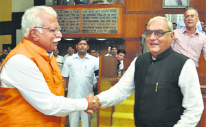 Former Chief Minister Bhupinder Singh Hooda (right) meets his successor Manohar Lal Khattar in the Vidhan Sabha on Monday.