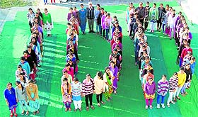 Students of Dronacharya Nursing College form a human chain at Chamunda in Kangra on Monday.