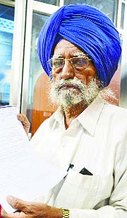 Bhupinder Singh shows some documents in Ludhiana on Monday.