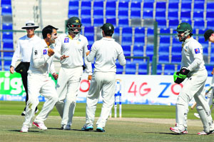 Pakistans Mohammad Hafeez (L) celebrates after claiming an Australian wicket during Day 5 of the second Test in Abu Dhabi on Monday