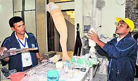 Hearing and speech impaired Trikam Parmar (L) and polio-hit Raman Solanki take part in the artificial limb-making contest during the 4th National Abilympics in Chandigarh.
