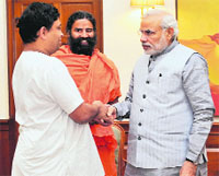 Yoga guru Ramdev and Acharya Balkrishan with Prime Minister Narendra Modi in New Delhi on Monday. Tribune photo: RAMESHWAR GAUR