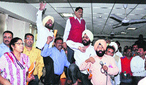 Congress councillors stand on tables to raise slogans against the ruling alliance during the MC House meeting
