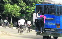 Passengers hanging on the rear end of a passenger bus in Ludhiana. a Tribune Photograph