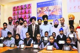 Social Work: Students of Pehal hold tablets given by American India Foundation under the tab-lab project inaugurated in Amritsar on Wednesday