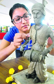 A student gives the final touches to a clay model during the youth festival at GADVASU.