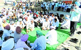 Arhtiyas hold a dharna against delayed payments at the Khanna grain market on Wednesday. 