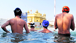 Sikh devotees bathe in holy sarovar (water tank) on the occasion of Guru Nanak Devs birth anniversary at the Golden Temple in Amritsar on Thursday
