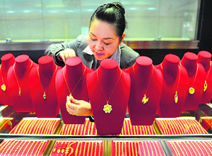 A shop assistant arranges gold accessories at a store in China. Gold on Thursday rebounded from the biggest drop of 2014 as as investors dumped the metal amid strength in the dollar.