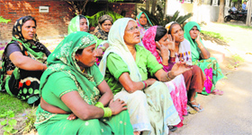 Residents of shanties sitting outside the ancestral house of local MP Kirron Kher to meet her, in Chandigarh on Thursday.