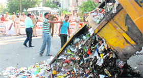 Protesting MC workers dump garbage near the residence of MLA Gian Chand Gupta in Sector 17, Panchkula, on Thursday.