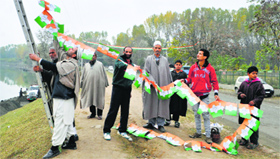 Congress workers put up party flags in Bandipora district on Thursday.
