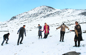 Tourists enjoy seasons first snowfall in the upper reaches of south Kashmirs Shopian district on Thursday.