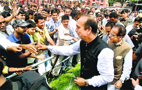 Former Union Minister Ghulam Nabi Azad shakes hands with party workers after attending a public rally in Akhnoor.