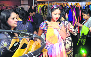 Visitors take a look at dresses during a trunk show on fashion and lifestyle accessories at a hotel in Ludhiana on Thursday.