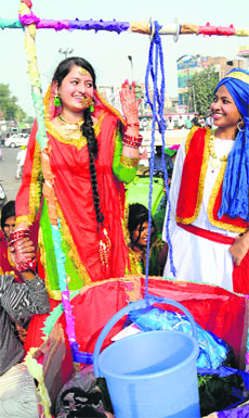 Girls dressed up in traditional attire take part in the Virasat Mela procession in Bathiinda on Friday.