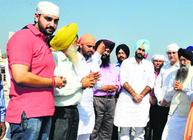 Sharanjit Singh Dhillon (extreme right) and Gulshan Kumar (second from right) donate land to residents of GK Estate Colony in Ludhiana on Thursday