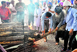 Maternal grandfather (right) lights the pyre of his grandson Mehram at the cremation ground in Mohali on Saturday