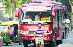 A passenger puts his life at risk standing on the steps of a bus. a file photograph