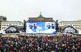 People wait in front of the Brandenburg Gate in Berlin on Sunday