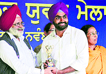 PAU Vice-Chancellor Dr Baldev Singh Dhillon presents the best actor award to Narjeet Singh during the youth festival in Ludhiana