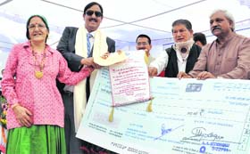 Chief Minister Harish Rawat presents the Dronacharya Sports Award to Narayan Singh Rana during a programme at his residence in Dehradun on Sunday