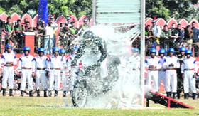 A BSF soldier performs a stunt during the 14th state foundation day programme at the Police Lines in Dehradun on Sunday