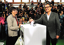 The president of Catalonias regional government, Artur Mas (R), casts his ballot in Barcelona on Sunday