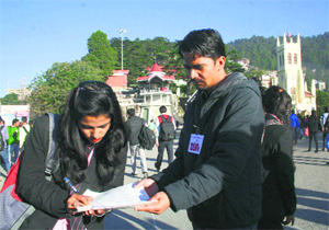 A student signs during a signature campaign organised by the DYFI in support of their demands on The Ridge in Shimla on Monday.