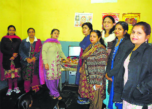 Members of the Chamera-III Women Welfare Committee distribute computers among underprivileged children in Chamba on Saturday.