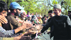 Congress leader Ghulam Nabi Azad shakes hands with party supporters in Kulgam district on Monday.