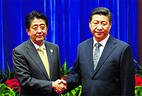Photo op?  China's President Xi Jinping (R) shakes hands with Japan's Prime Minister Shinzo Abe on the sidelines of the APEC meetings in Beijing on Monday.