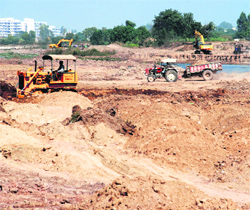 The work of levelling the ground near a nullah going on in full swing at Gajipur village in Zirakpur.