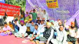 Members of the Class IV Government Employees Union stage a protest outside the Government College for Girls, Civil Lines, Ludhiana, on Tuesday.